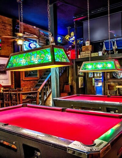 Vibrant pool hall with neon-lit billiard tables, eclectic memorabilia, and vintage beer signs.