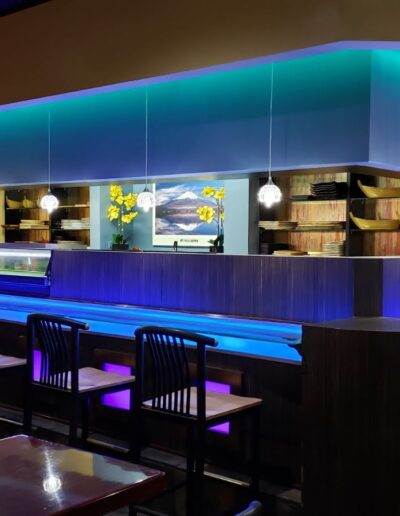 Modern sushi bar with blue lighting and contemporary decor.
